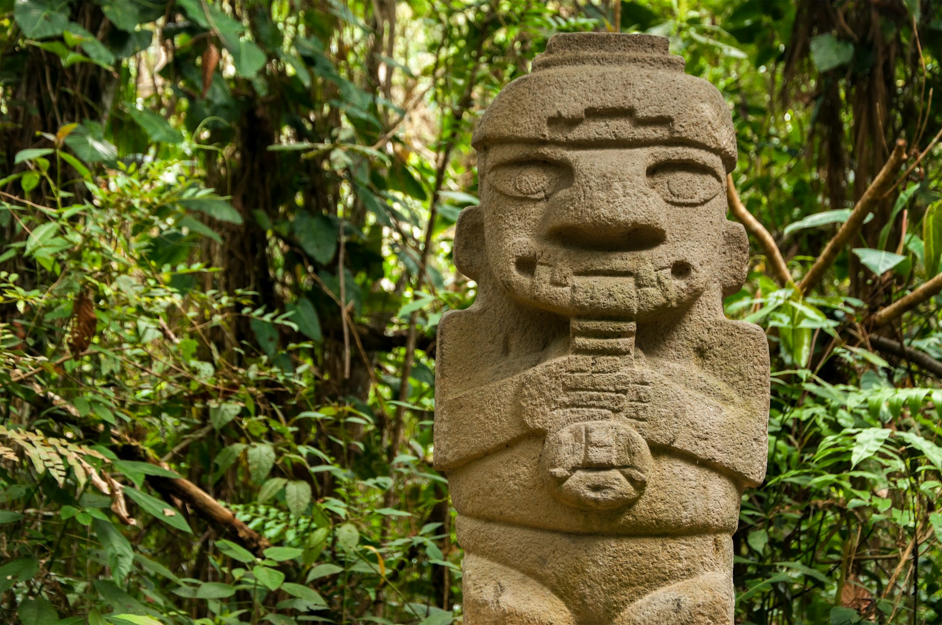 A pre-Columbian stone figure of a flute-playing person at Parque Arqueológico San Agustín, Colombia