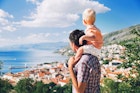 Father and son look at a view over the Croatian coast near Split