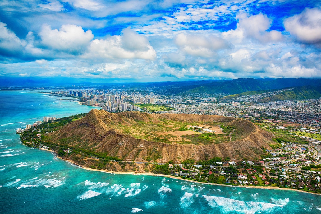 The beautiful coastline of Honolulu Hawaii shot from an altitude of about 1000 feet during a helicopter photo flight over the Pacific Ocean with Diamond Head in the foreground.