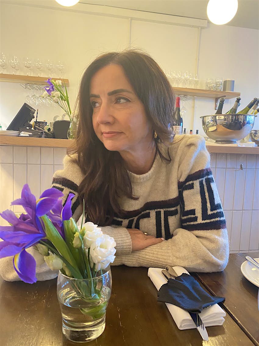 Fionnuala-McCarthy.jpg Fionnuala McCarthy sits at a table with flowers on it and wine in the background.