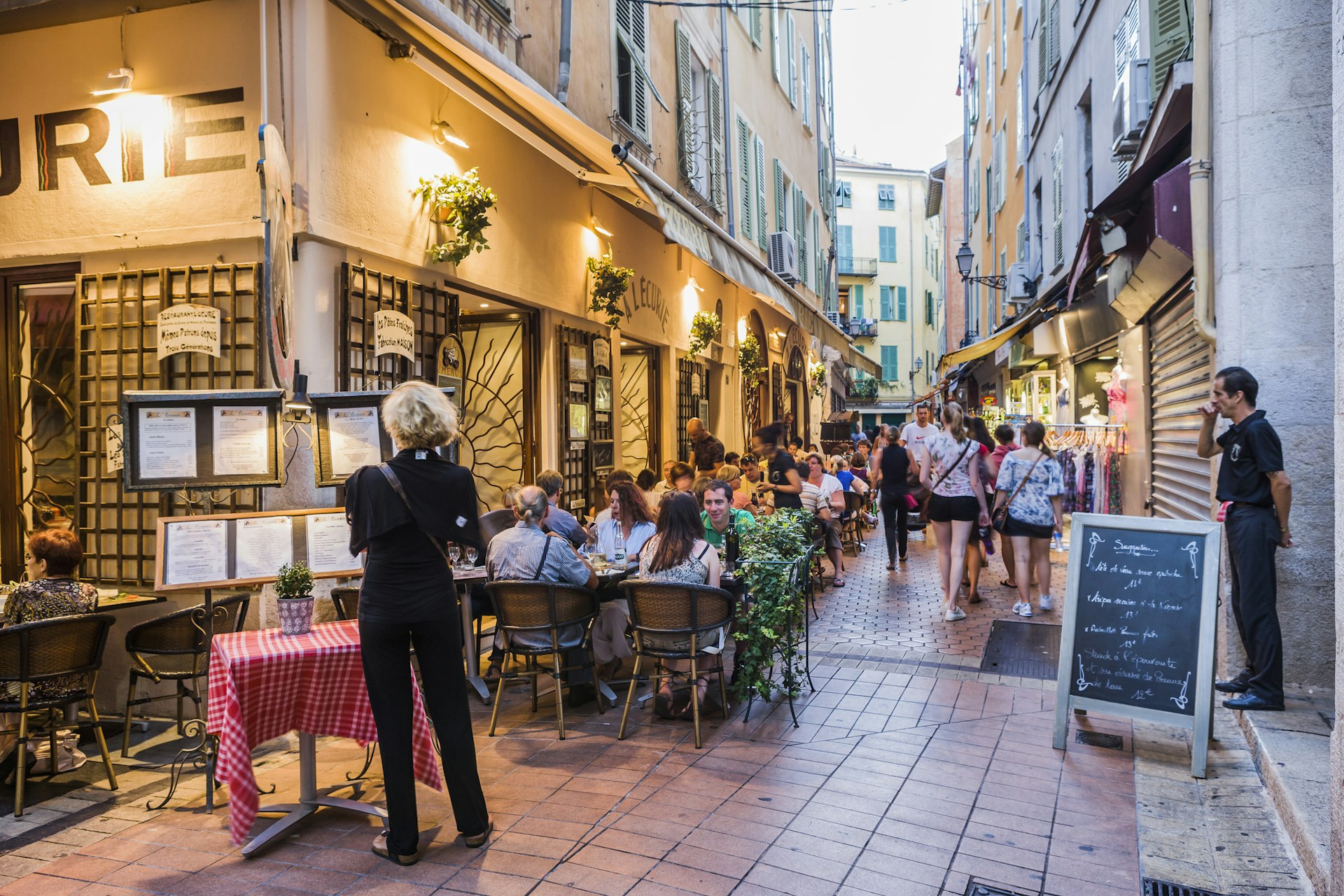 People are seated outside a restaurant in the evening in Vieux Nice, France