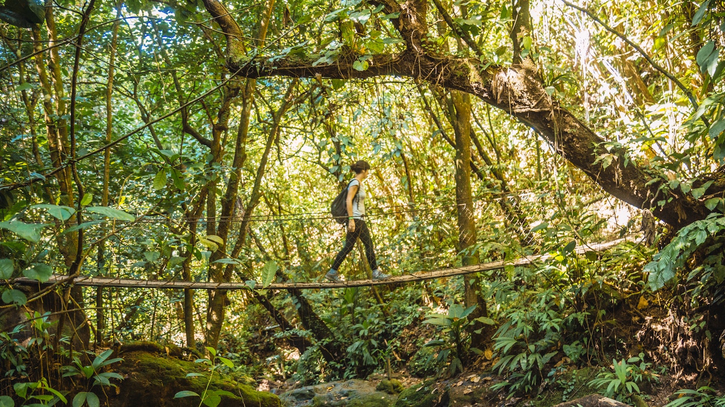 A young girl on a wooden bridge of the Cerro Azul Meambar National Park (Panacam) in Yojoa. Honduras