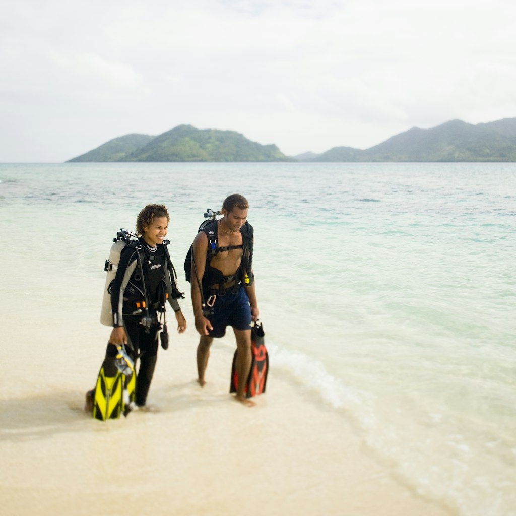 A young Fijian couple walks on the beach on Picnic Island.