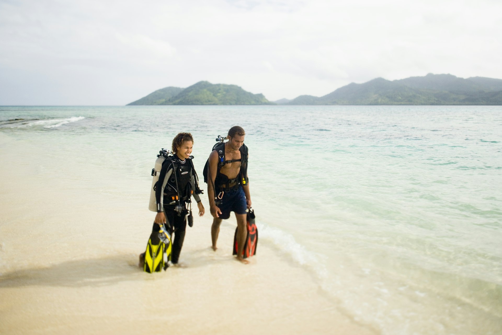 A young Fijian couple walks on the beach on Picnic Island