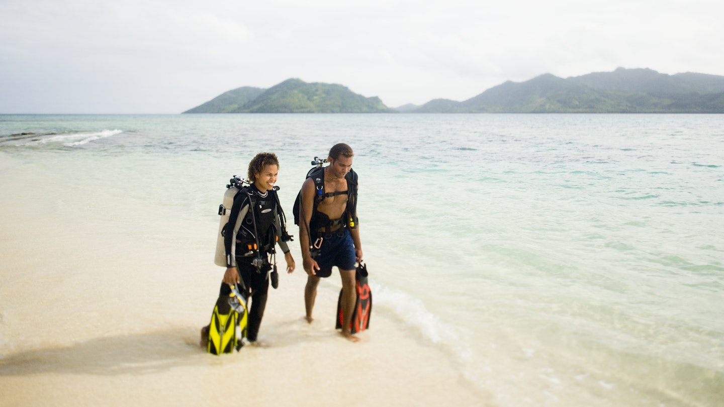 A young Fijian couple walks on the beach on Picnic Island.