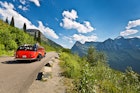 Glacier National Park, Montana, USA - August 2, 2016: Visitors to Glacier National Park touring the park along the breathtaking "Going To The Sun Road" in cars or in park tour buses. The scenic road wind through the national park along steep mountain cliffs and valleys.