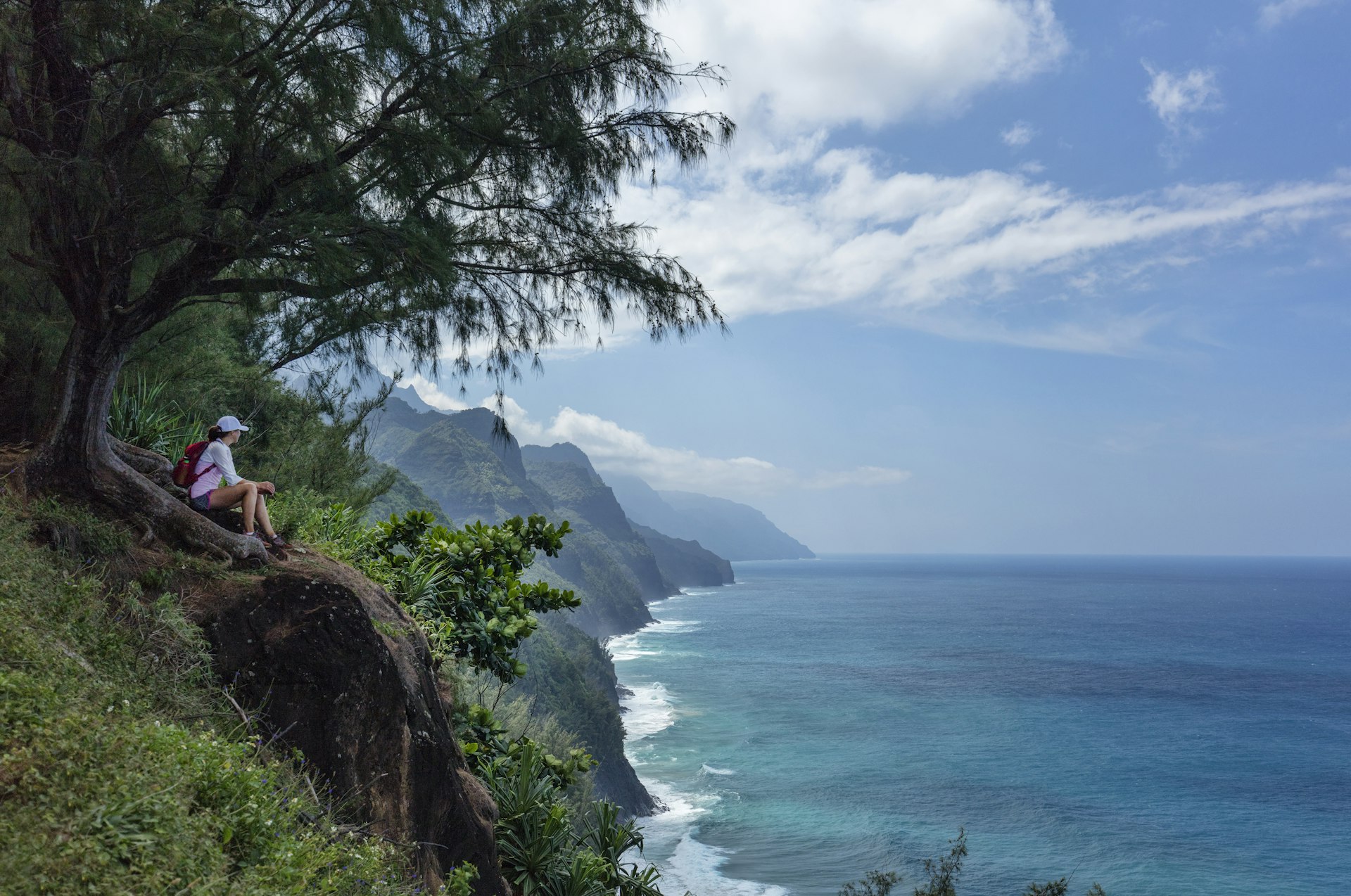 A hiker taking in the Na Pali Coast view, Kauai, Hawaii