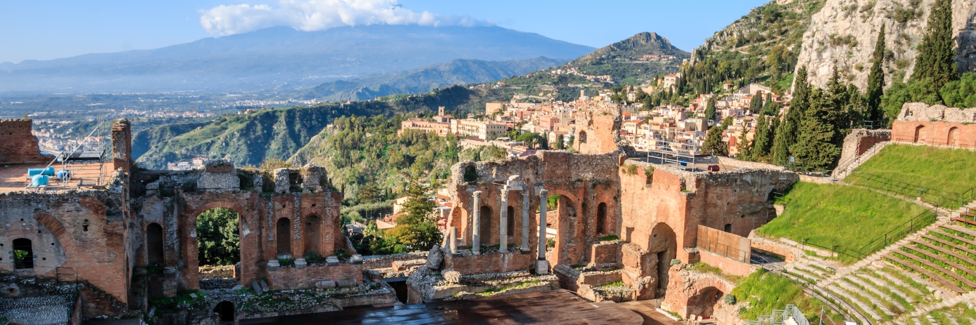 The Greek theatre (Teatro Greco) and Mount Etna, Taormina, Sicily; The Greek theatre with smoking Mount Etna volcano in the background, Taormina, Sicily, Italy