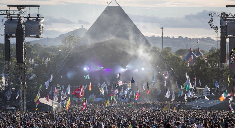 GLASTONBURY, ENGLAND - JUNE 25:  People gather in front of the Pyramid Stage  at Worthy Farm in Pilton on June 25, 2017 near Glastonbury, England. Glastonbury Festival of Contemporary Performing Arts is the largest greenfield festival in the world. It was started by Michael Eavis in 1970 when several hundred hippies paid just £1, and now attracts more than 175,000 people  (Photo by Matt Cardy/Getty Images)