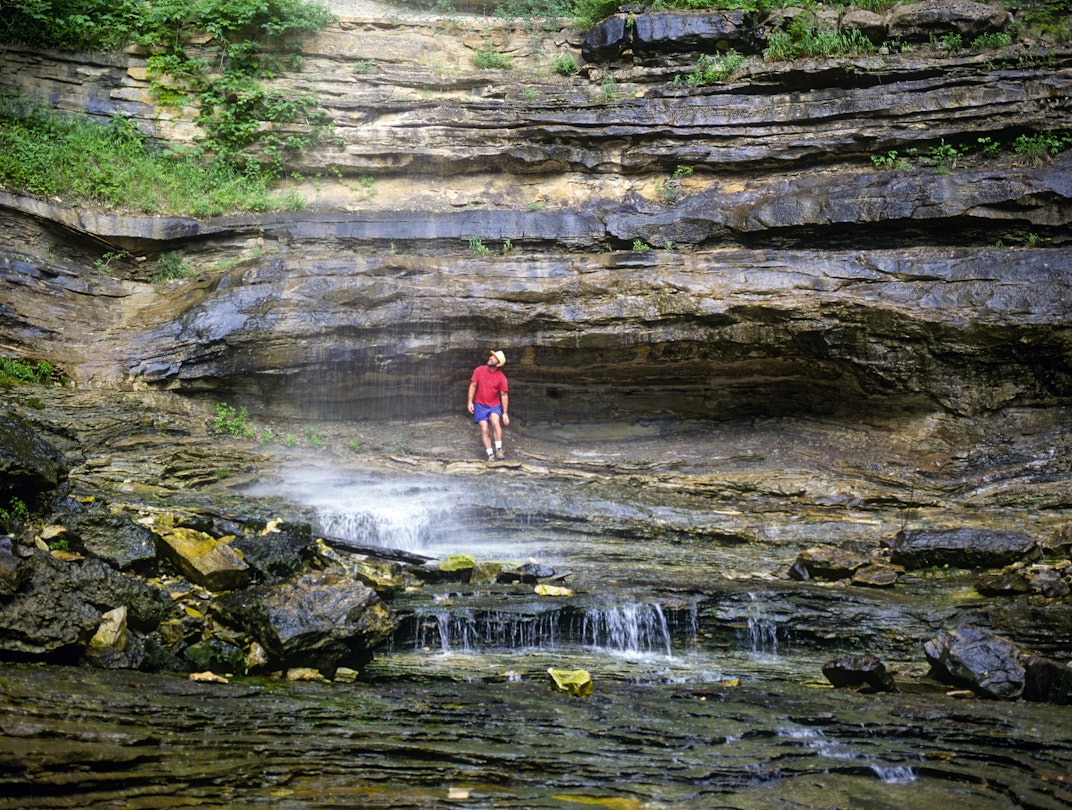 A hiker cools off beneath Hemmed-in-Hollow waterfall in the Bufffalo National River Canyon in the Ozark Mountains of northwestern Arkansas.