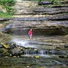 A hiker cools off beneath Hemmed-in-Hollow waterfall in the Bufffalo National River Canyon in the Ozark Mountains of northwestern Arkansas.