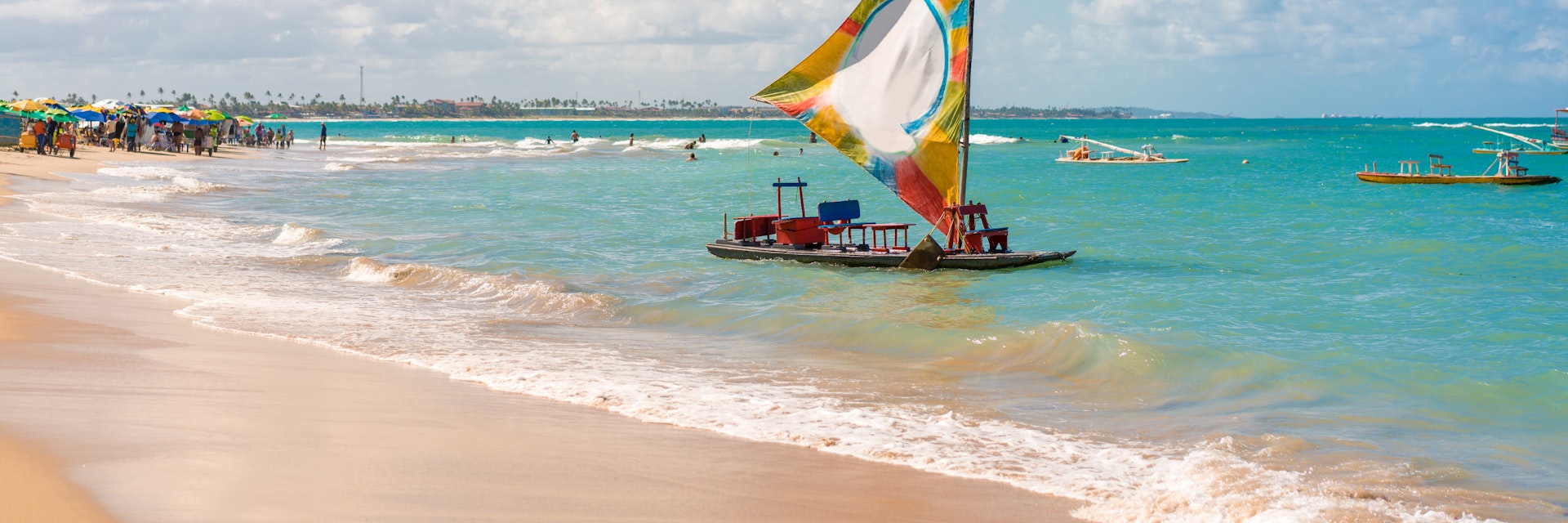Small sail boat in the water at Porto de Galinhas Beach.