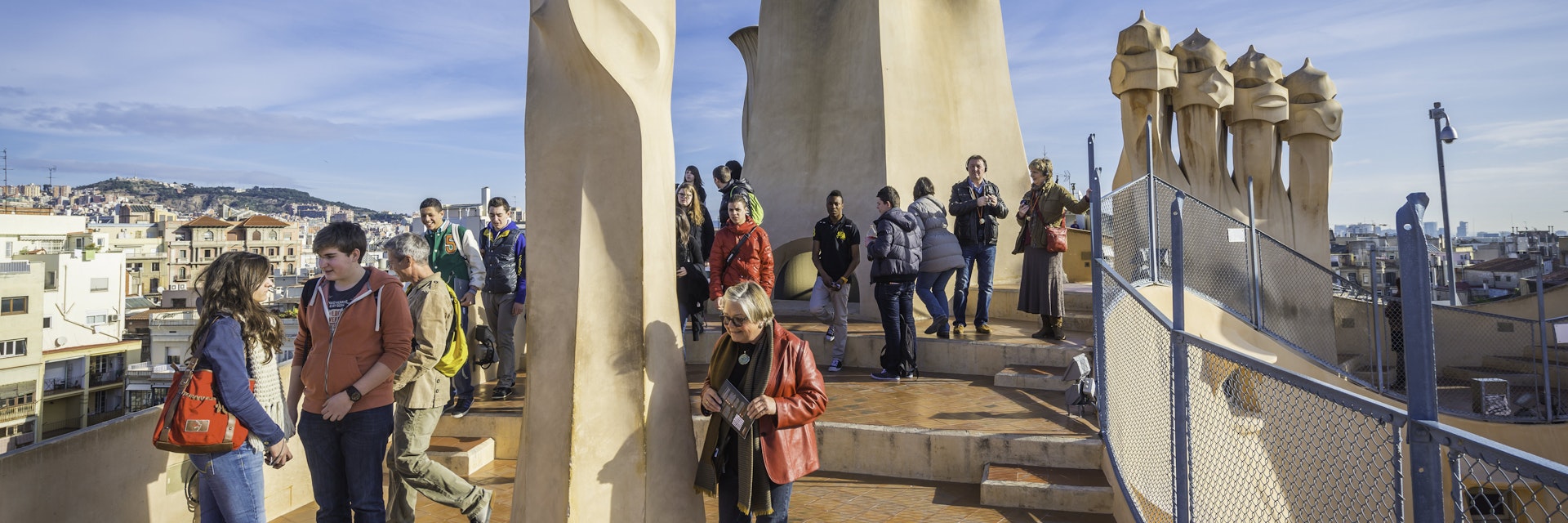 Barcelona, Spain - 14th February 2013: Tourists enjoying their visit to the rooftop of Casa Mila, La Pedrera, to see the iconic Gaudi chimneys that overlook the Sagrada Familia and the heart of downtown Barcelona, Spain.