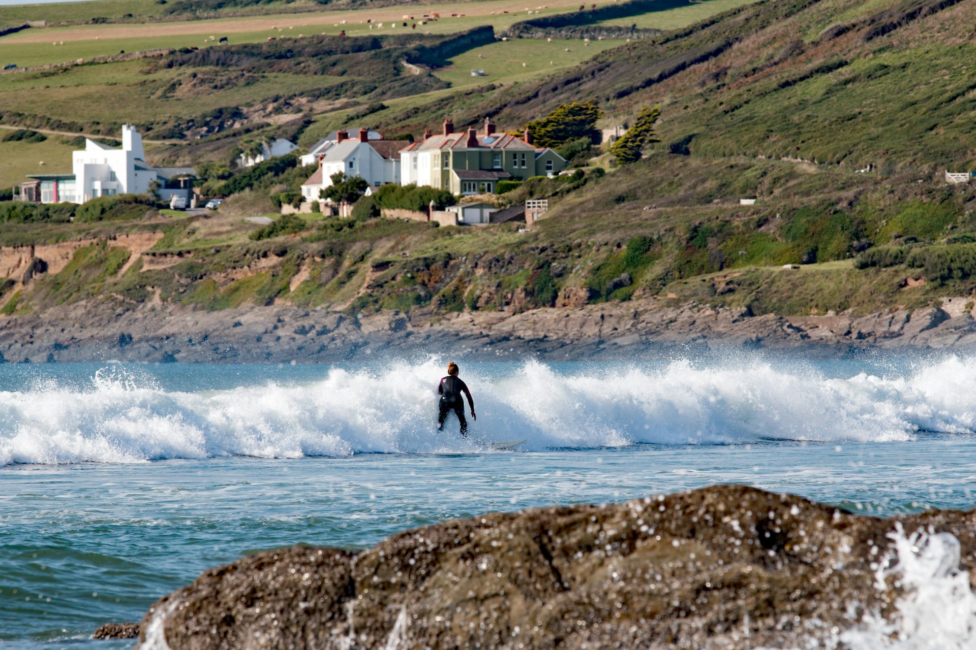 Surfer walking out towards the crashing waves