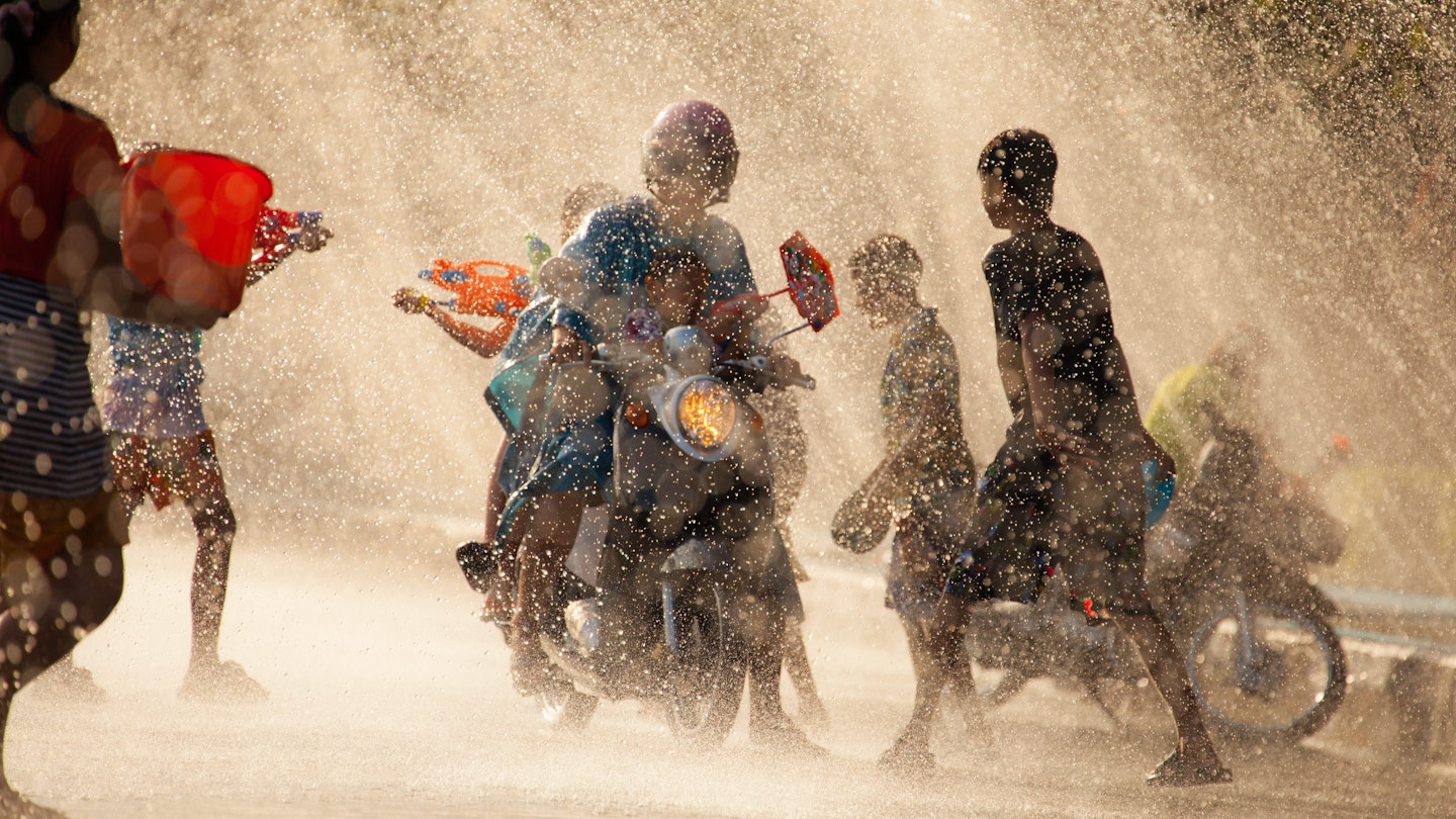 People shooting water guns and splashing water on each other in the city of Chanthaburi during Songkran Festival.
