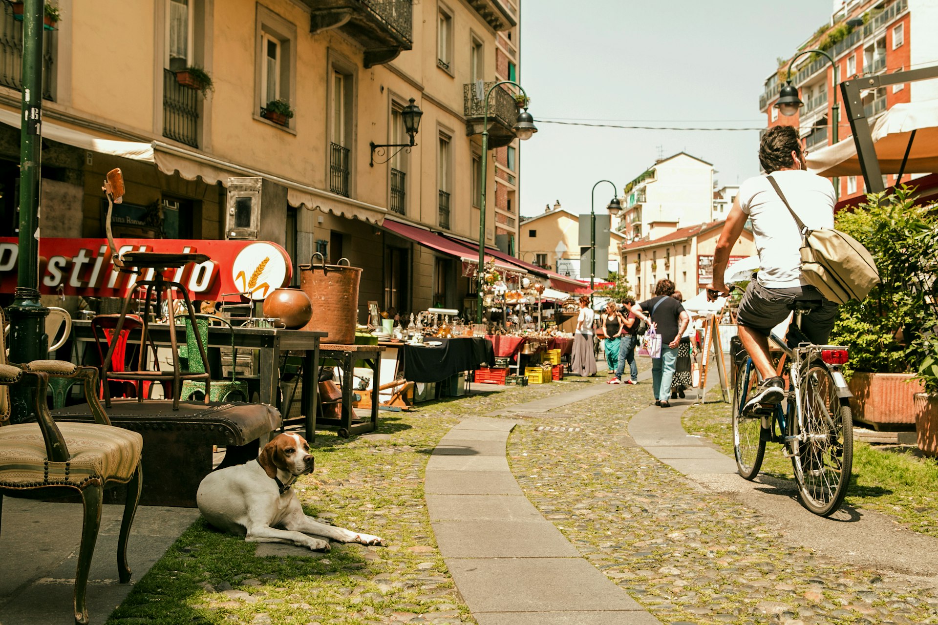 Scene of the Balon flea market in Turin with a cyclist passing through