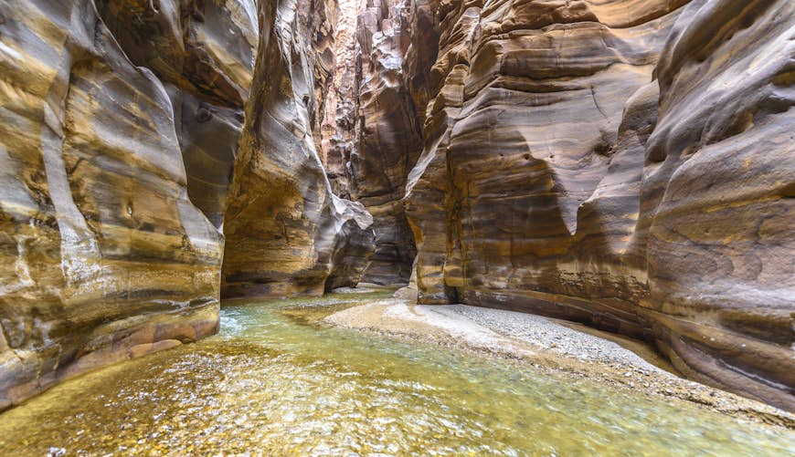 Rocky cliffs and trickling water at al Mujib Natural Reserve, known as the Grand Canyon of Jordan