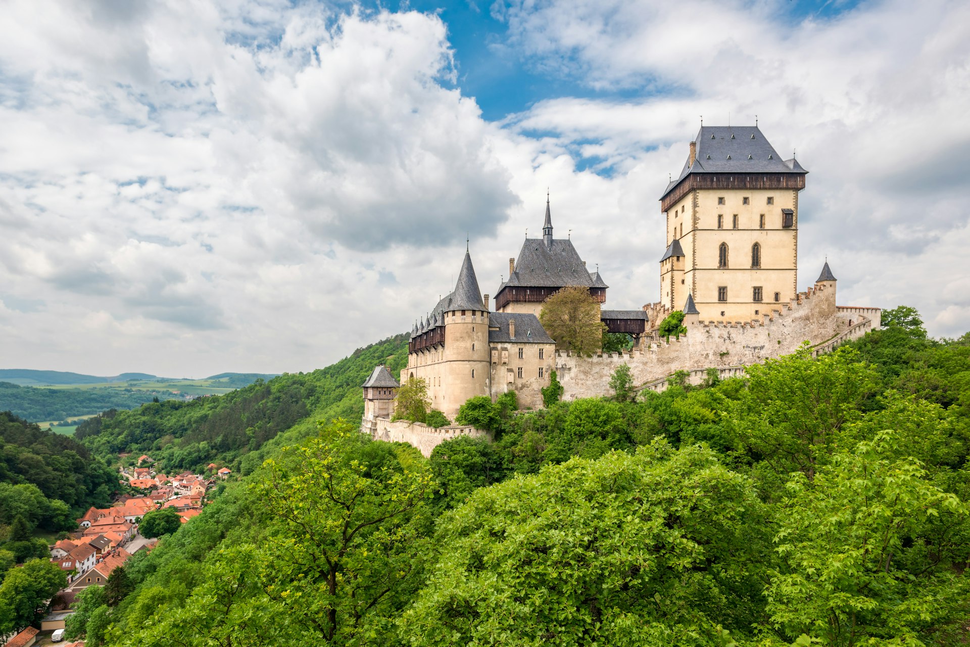 De gotiska tornen på slottet Karlštejn reser sig över floden Berounka