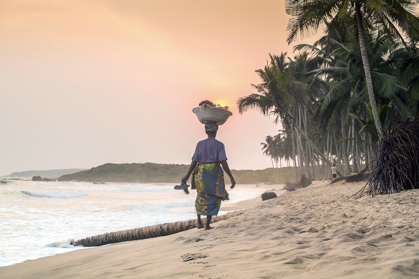 African woman in front of the sunset on the beach in Ghana