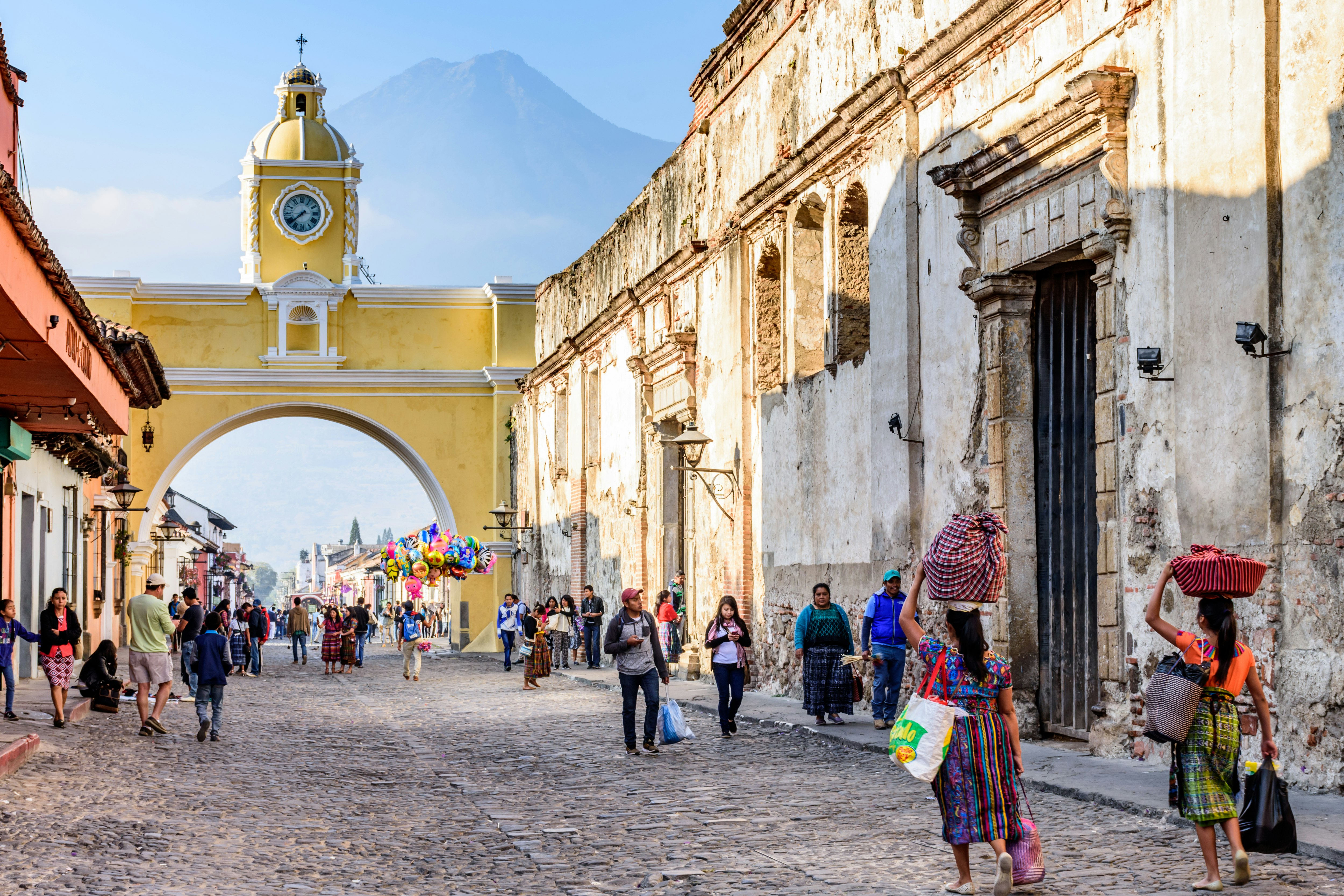 Locals and tourists walk by the Santa Catalina arch in Antigua, Guatemala
