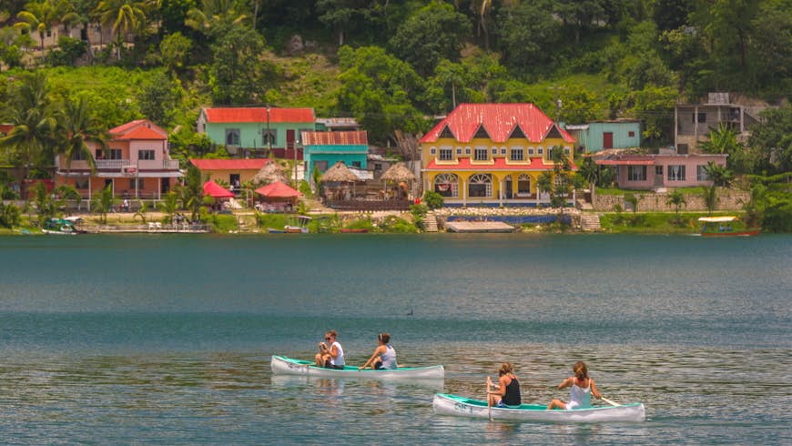 Tourists paddle canoes on Peten Itza lake in Guatemala