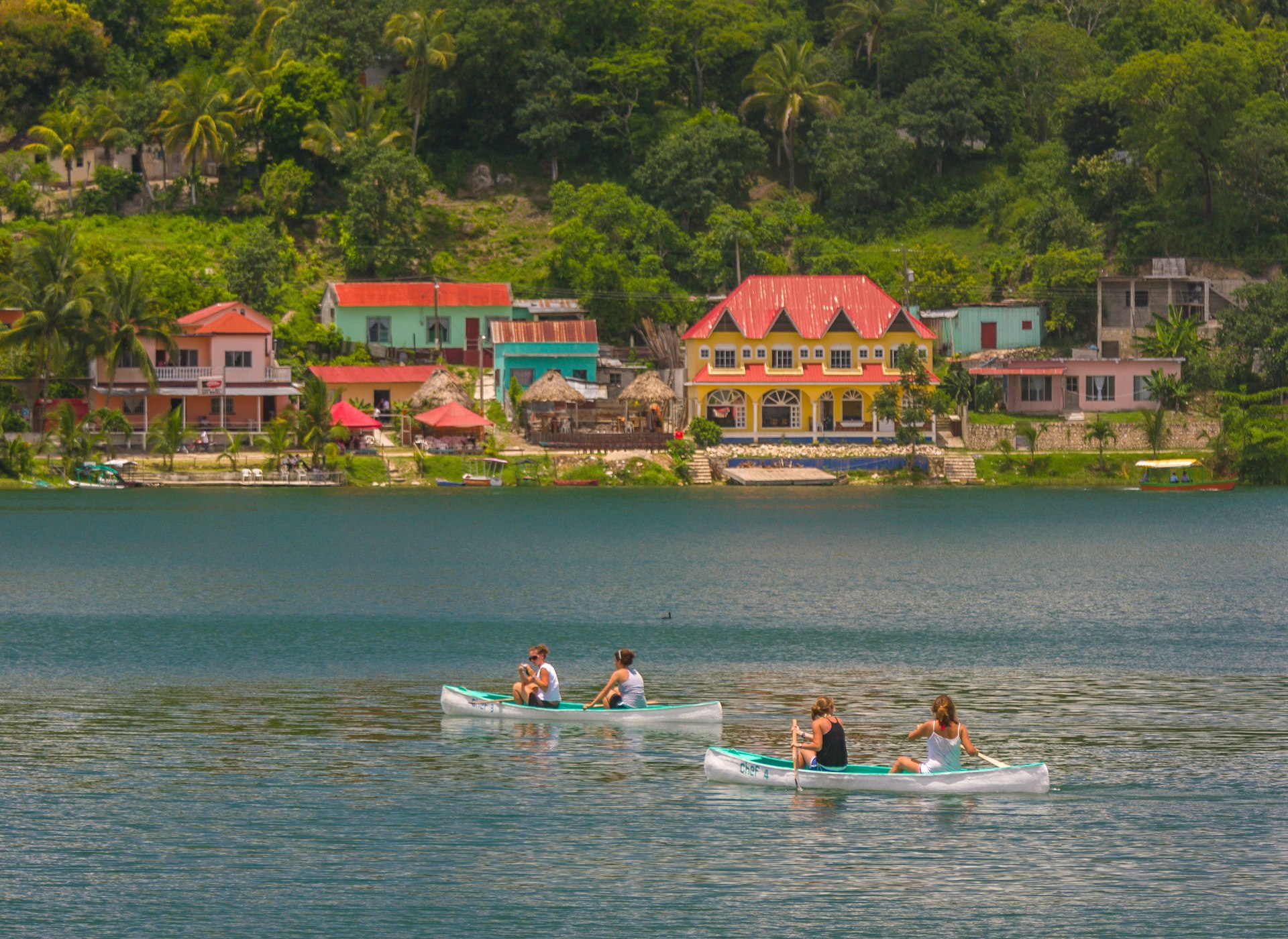 Tourists paddle canoes on Peten Itza lake in Guatemala