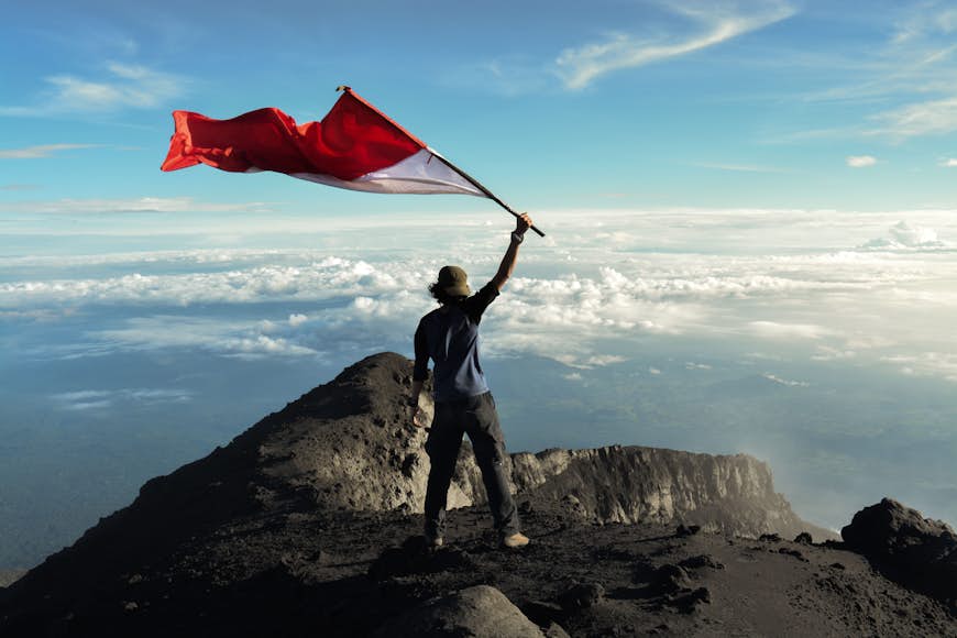 A man waves a flag atop Gunung Kerinci, Indonesia 