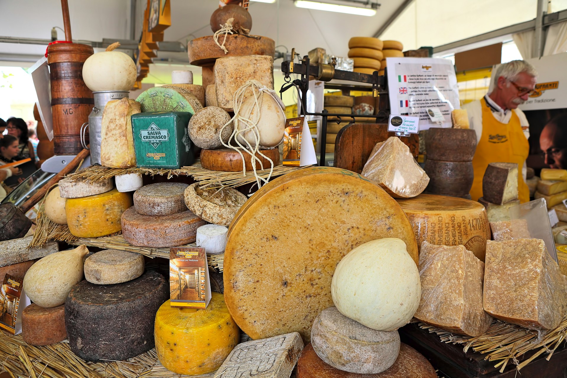 Wheels of mature cheese piled on a stand in Bra, Piedmont, Italy