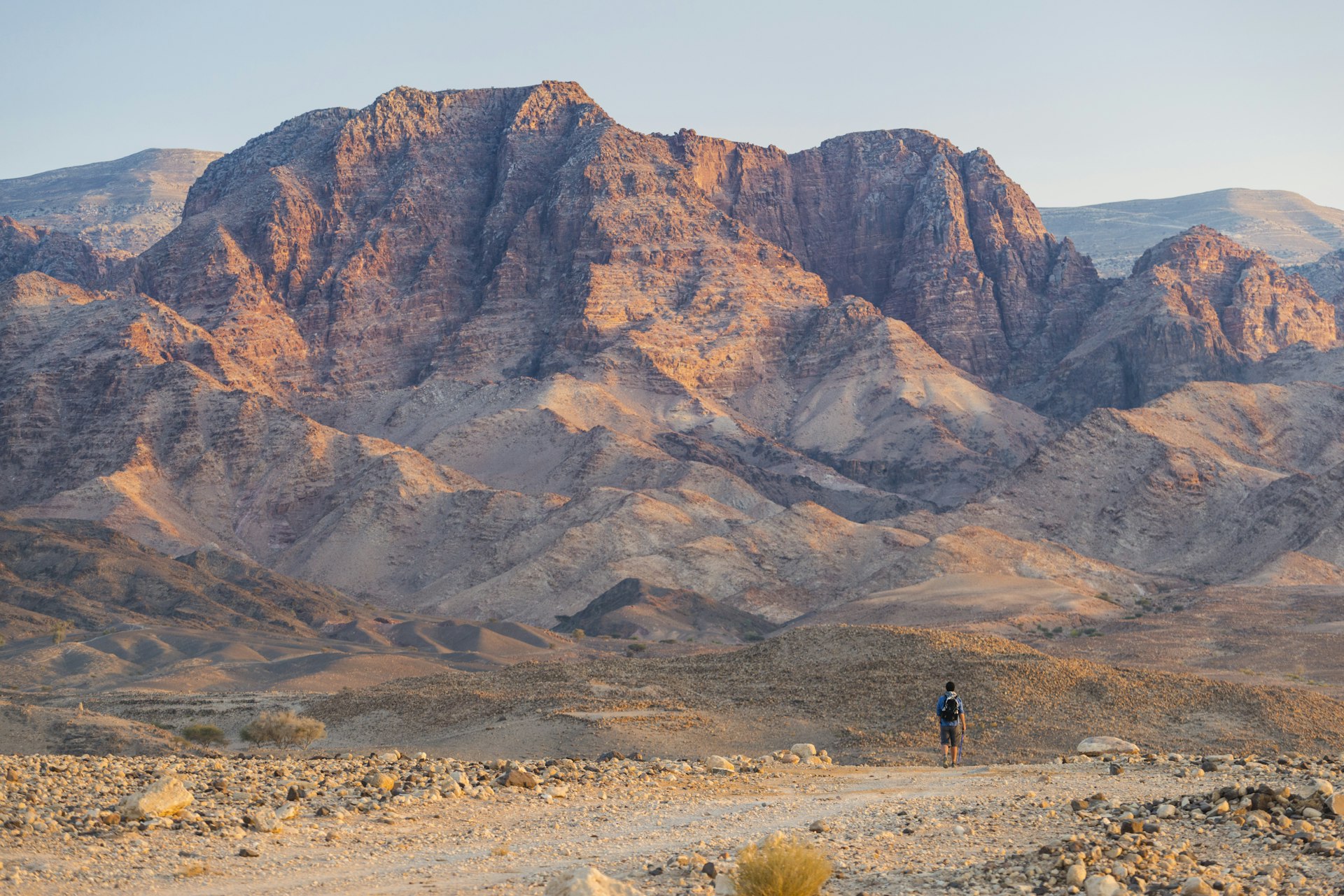 Man hiking towards Wadi Feid from the desert country of Wadi Feynan. 