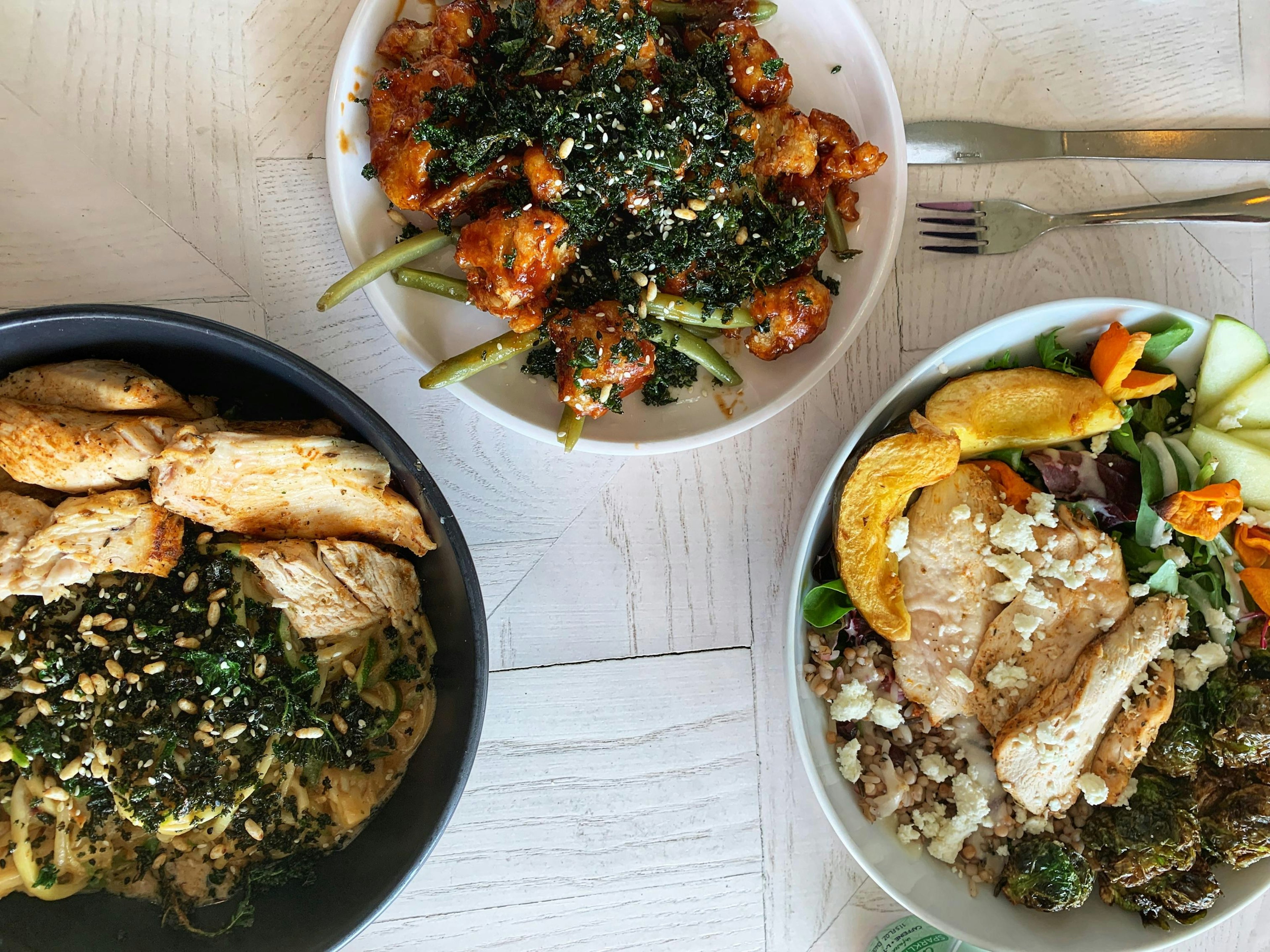 An overhead view of three dishes on a table in Naive restaurant in Louisville