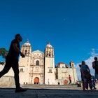 People in silhouette in front of the Templo de Santo Domingo de Guzmán, in Oaxaca, Mexico