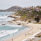 A view from the hilltop of the action on a beautiful sandy beach in Cabo San Lucas, Mexico