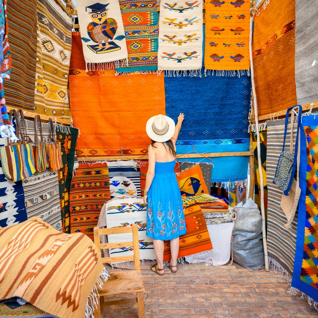 Woman admiring the handmade rugs in Oaxaca valley, Mexico