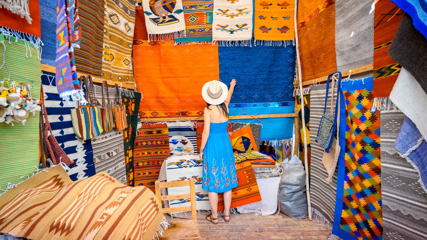 Woman admiring the handmade rugs in Oaxaca valley, Mexico