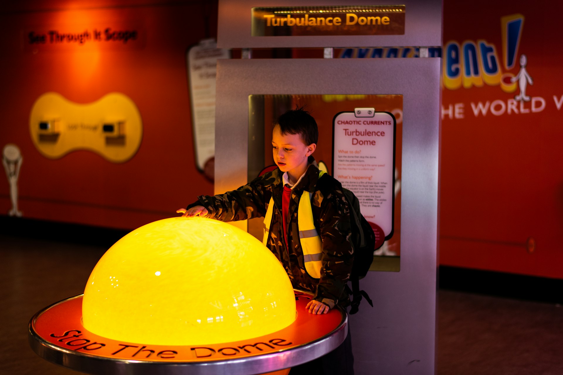 A young boy reaches out to touch a glowing yellow dome in a hands-on interactive gallery in Manchester's Science Museum