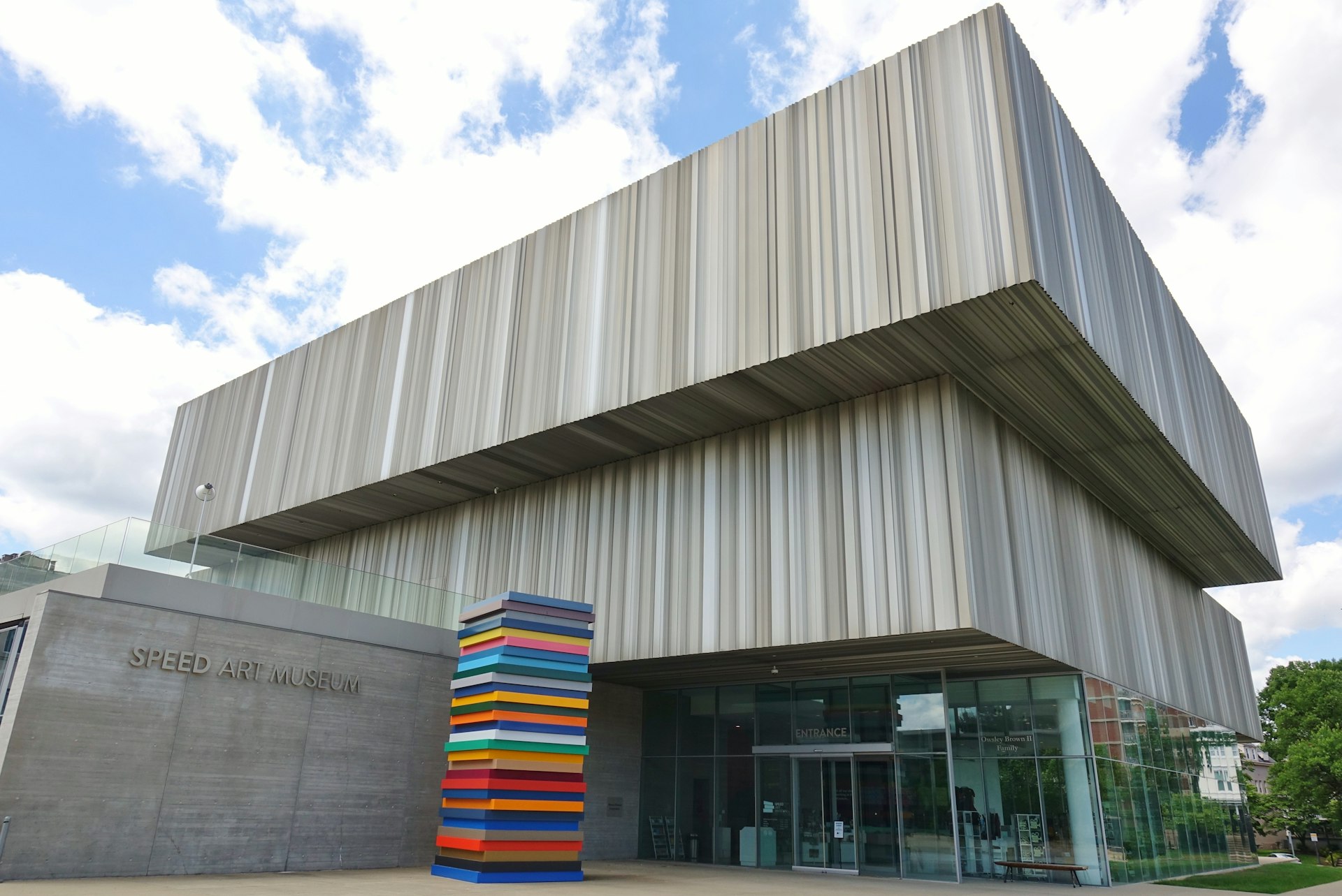 Exterior view of the Speed Art Museum located at the University of Louisville in Kentucky, United States which includes a sculpture that looks like an uneven stack of colourful books and fritted glass trim.