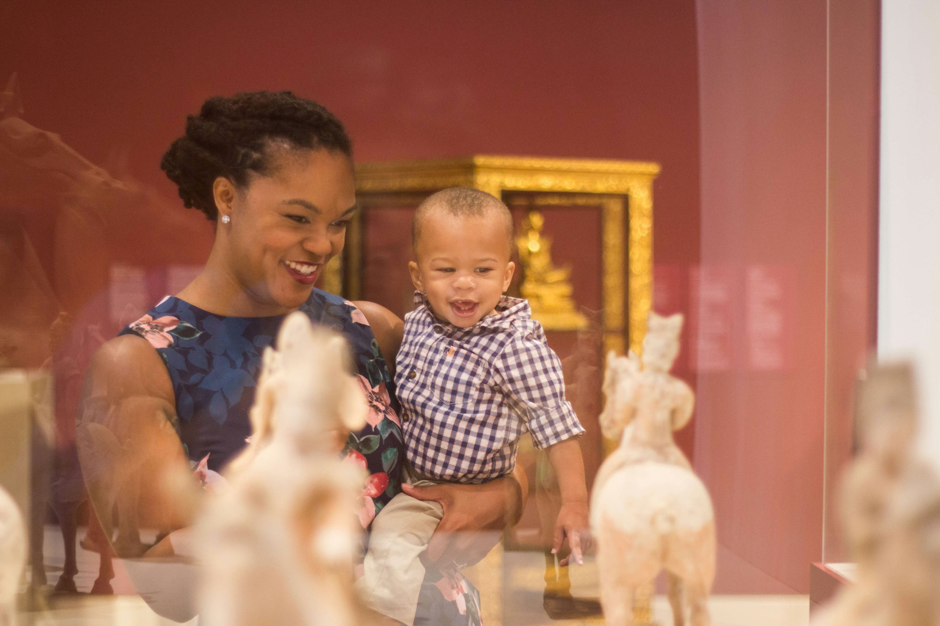 A woman holding a small child and looking at a display at the Crocker Art Museum, Sacramento