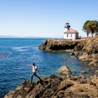 Caucasian man walking on rocks near the lighthouse on San Juan Island, Washington