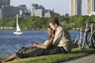 Disabled man reading with his partner by the water in Boston
