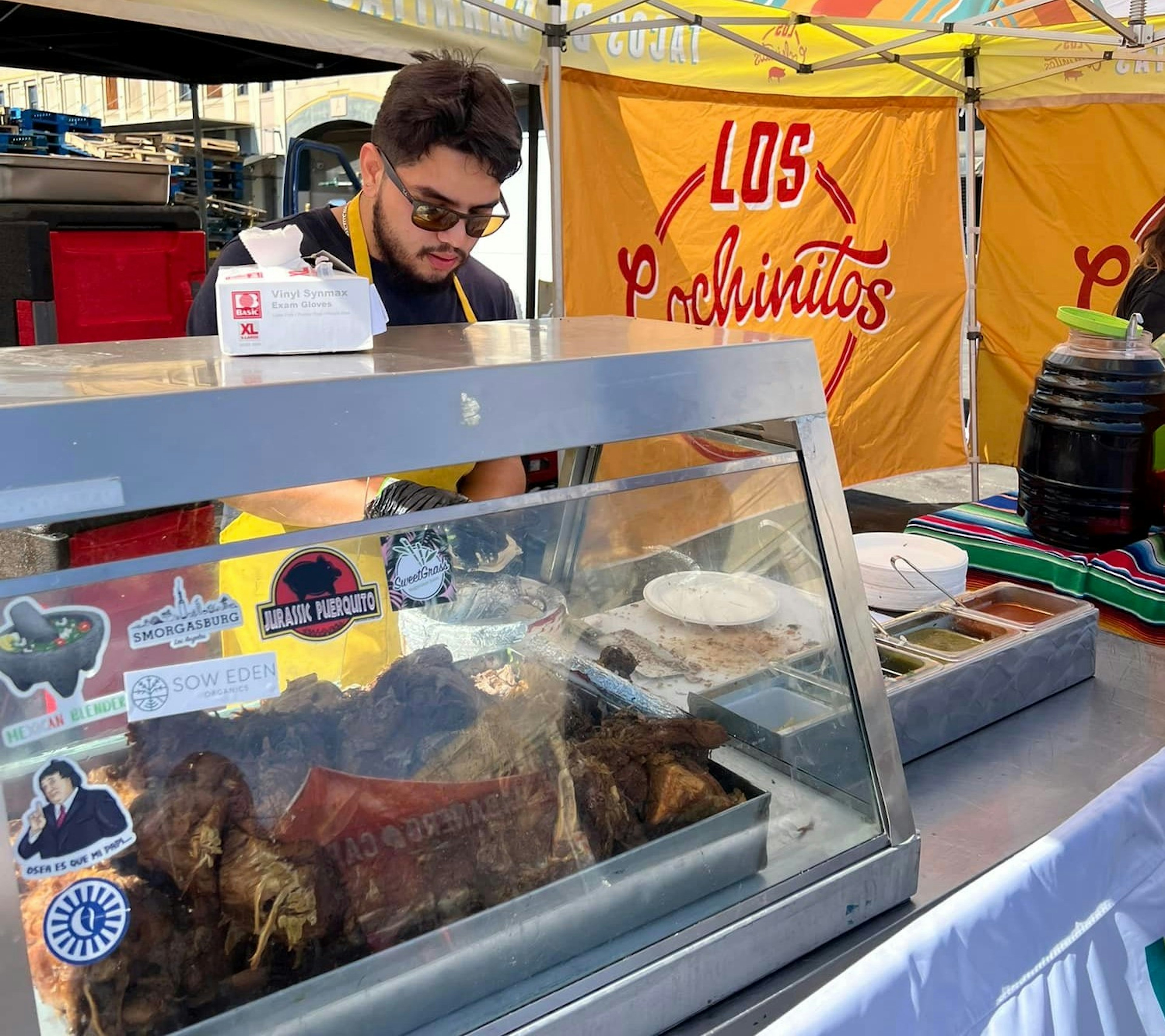 A person behind the counter at Los Cochinitos