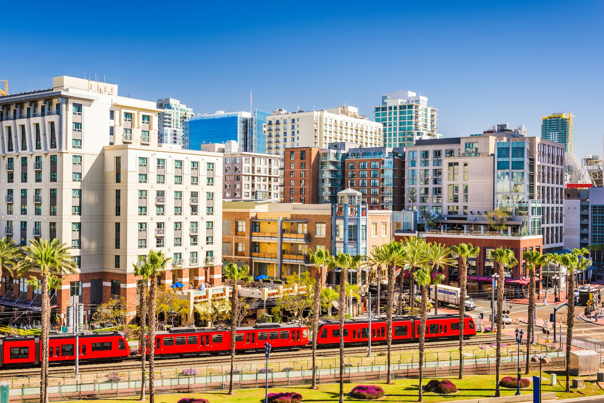 A light rail train passes by the buildings of downtown San Diego, California, USA