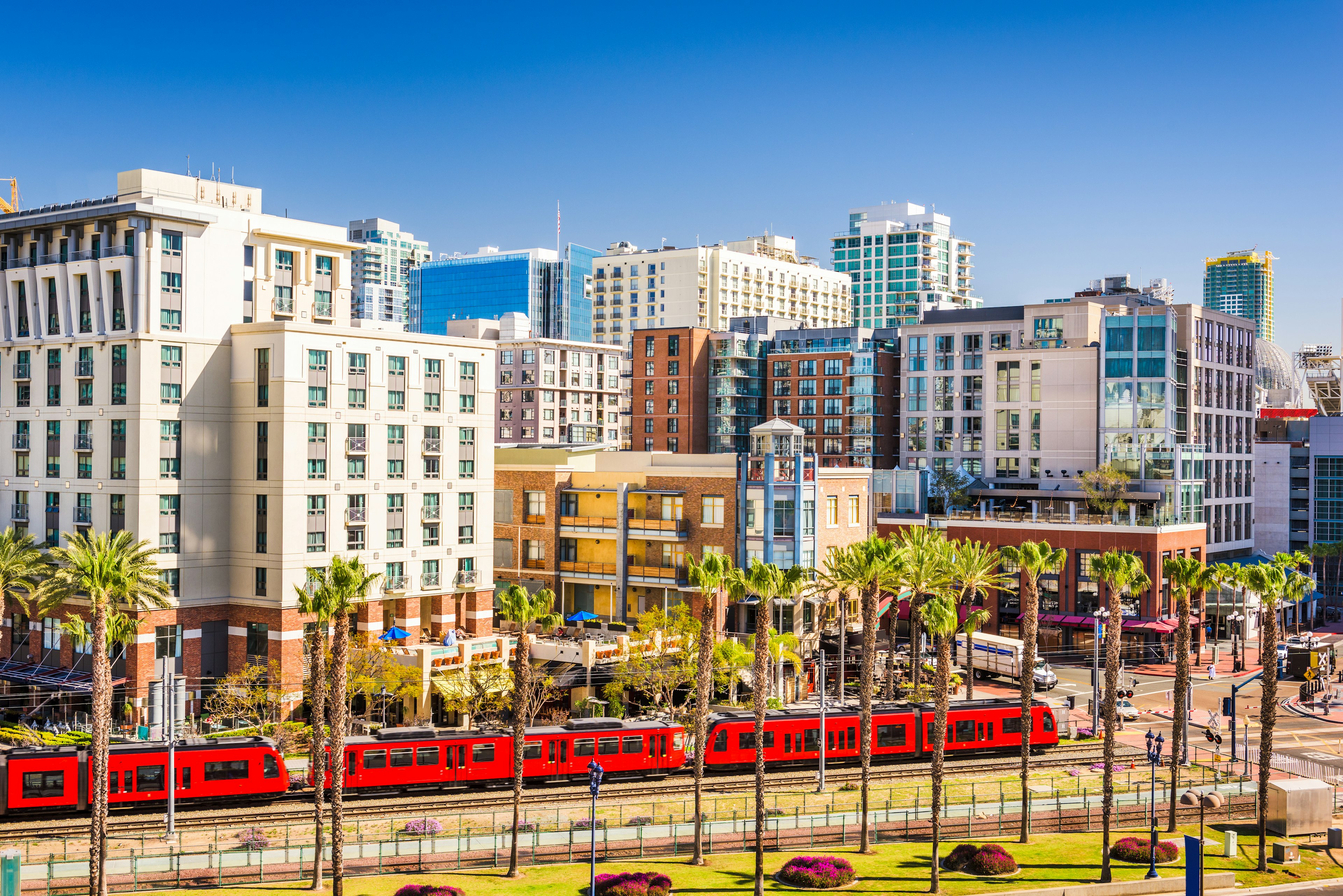 A light rail train passes by the buildings of downtown San Diego, California, USA