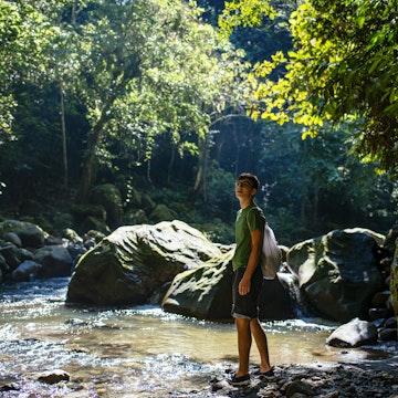 Young traveller is walking along a jungle stream in the amazon forest / Tarapoto/ north peru/ South America