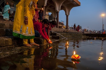 Nasik, India - February 23, 2014: People put candles in pool at night during the puja ceremony.