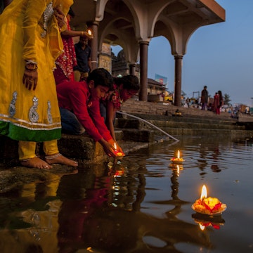 Nasik, India - February 23, 2014: People put candles in pool at night during the puja ceremony.