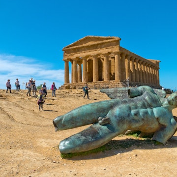 April 2, 2018: The Icarus statue, with tourists visiting the Temple of Concordia in the background.