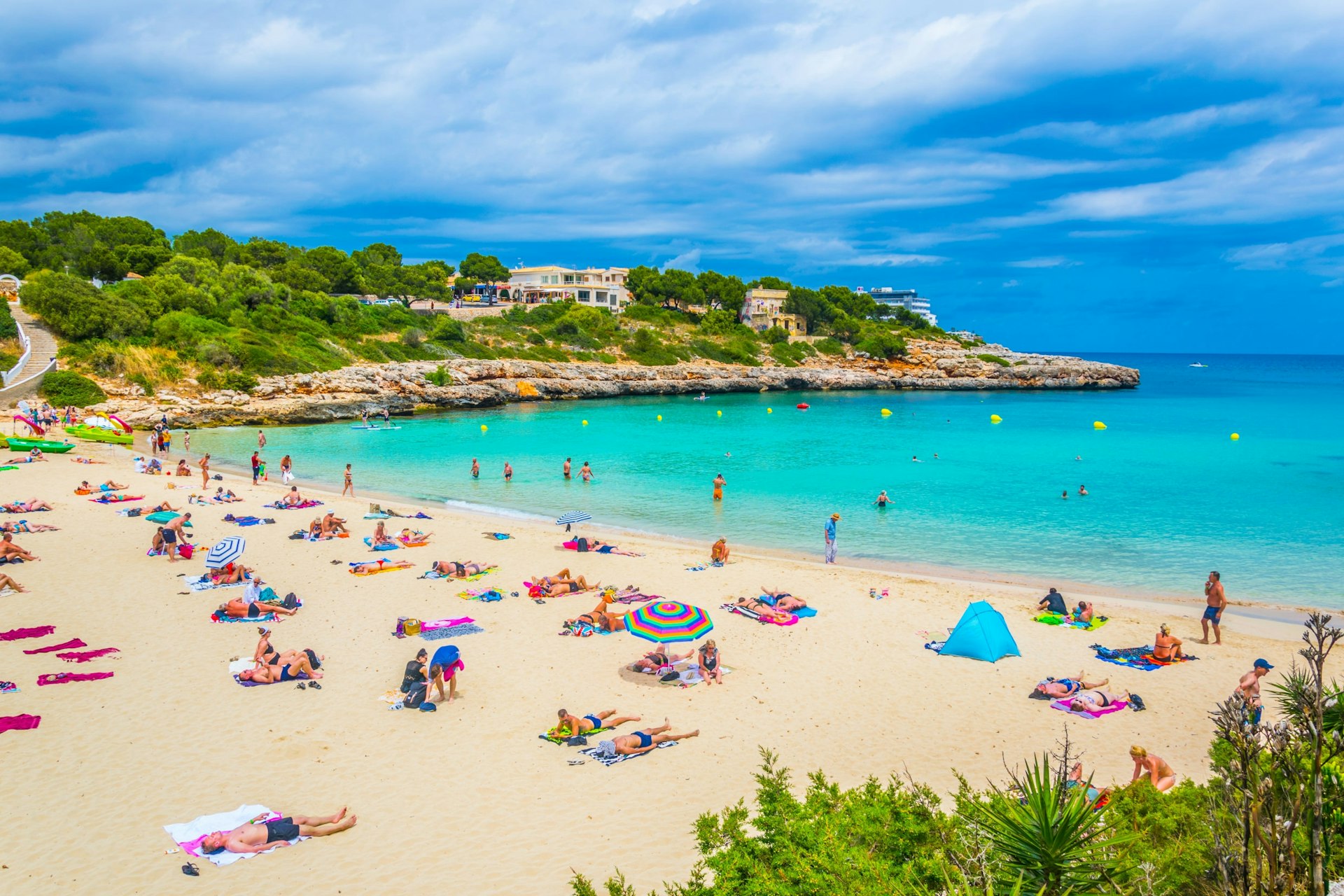 People sun bathing and swimming at Cala Marcal beach