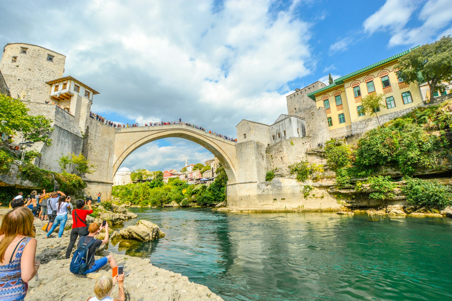 Tourists watch a daredevil diving into the Neretva River in Mostar, Bosnia and Herzegovina