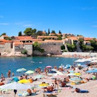 18 AUGUST, 2015: Visitors crowd Sveti Stefan Beach and Island area on a sunny summer day.