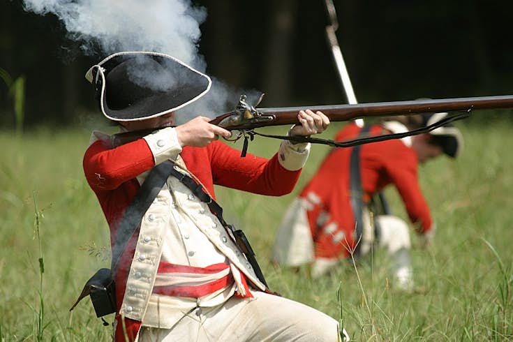 English redcoat soldier firing a rifle during a re-enactment in Yorktown, Virginia